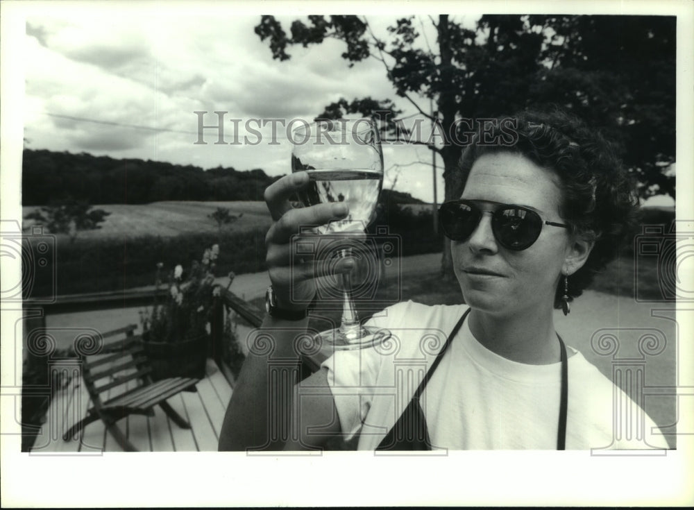 1993 Leisa Bauer hefts a glass of Seyval Blanc at New York vineyard - Historic Images