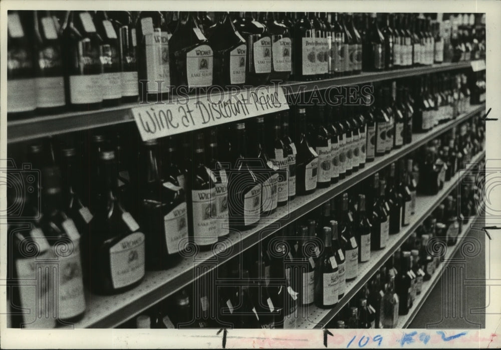 1980 Bottles of wine line shelves at liquor store - Historic Images