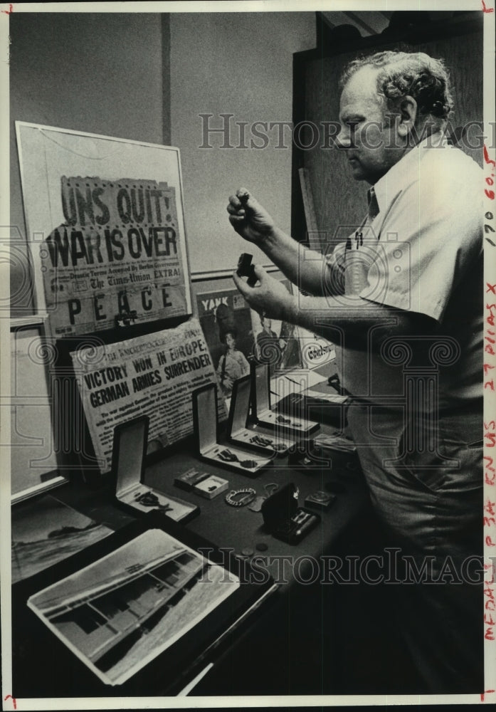 1977 John Nelson examines World War II relics in Albany, New York - Historic Images