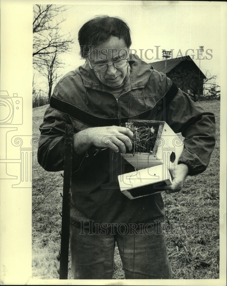 1983 Donald Wilkins cleans nest from birdhouse in Galway, New York - Historic Images