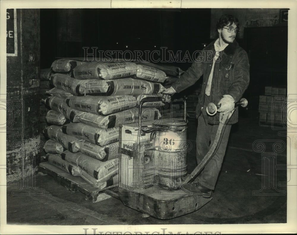 1984 Press Photo Bob Jones with skid of wheat flour for Kenya, Albany - Historic Images