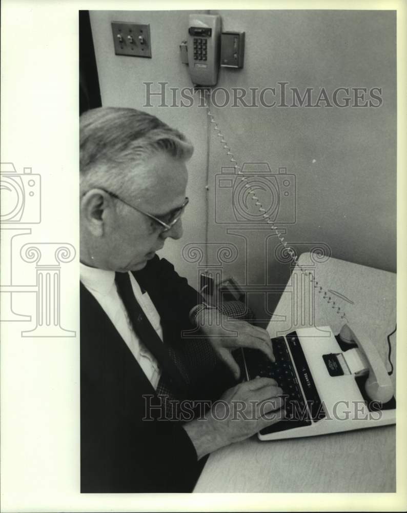 1987 Schenectady, NY police officer uses telecom device for the deaf - Historic Images