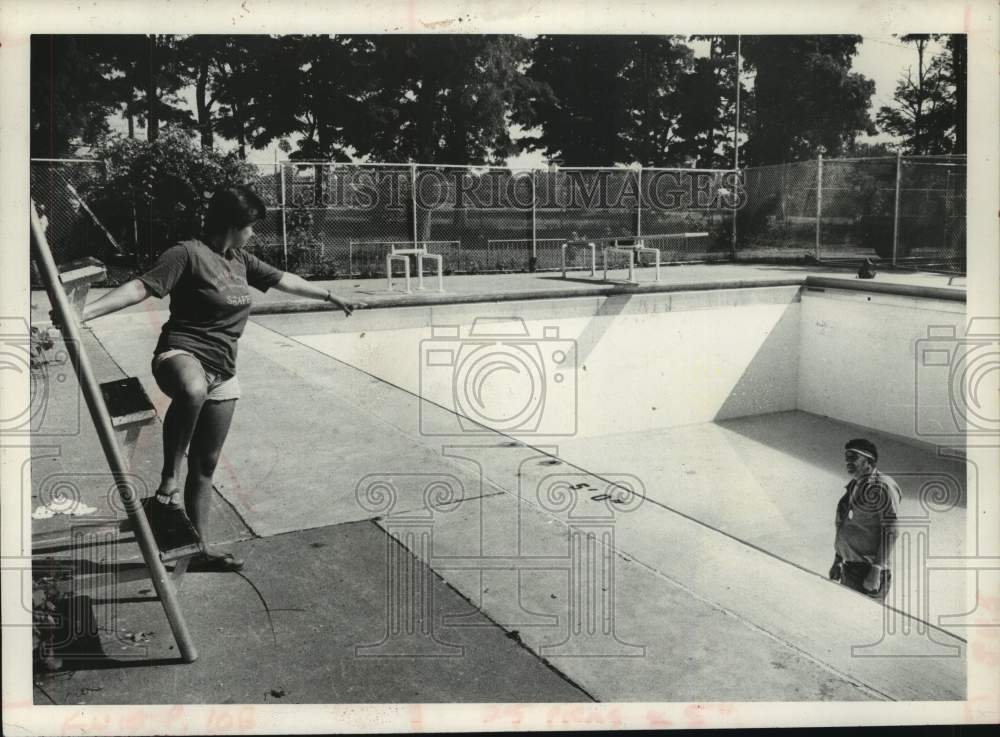 1980 Schenectady, NY parks crew drains park pool to remove glass - Historic Images