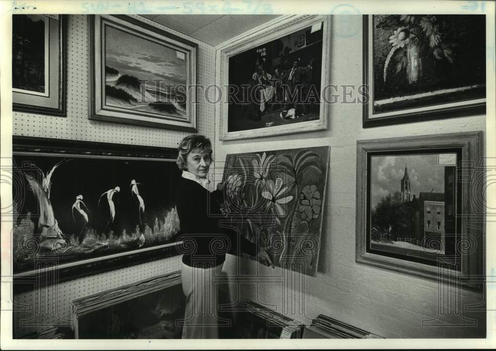 1976 Bea Wiggins hangs painting in New York art gallery - Historic Images