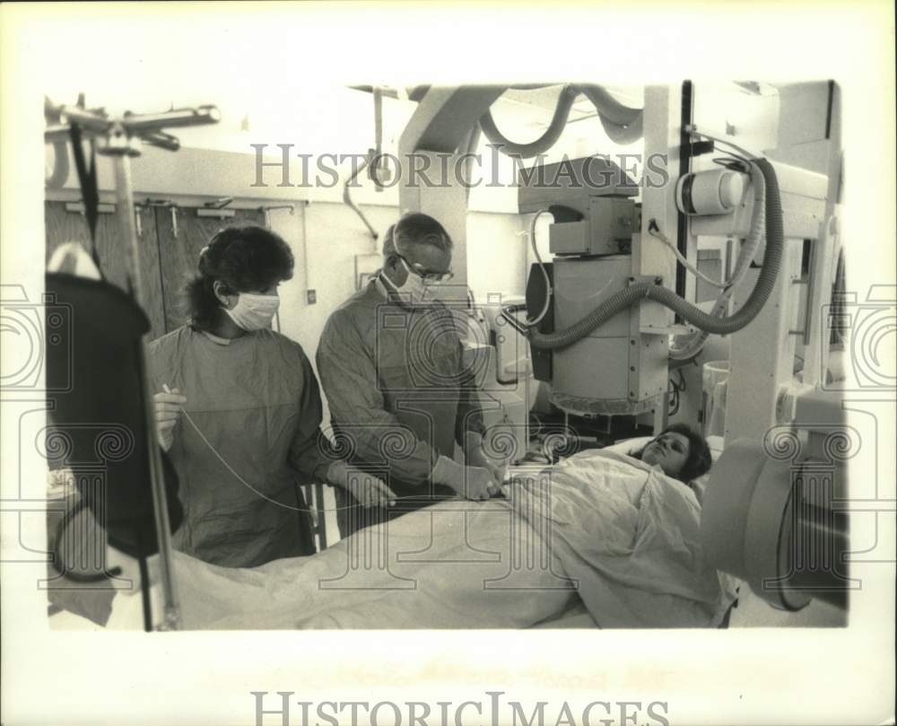 1985 Press Photo Arthur J. Wendte performs a catheterization on unknown patient. - Historic Images