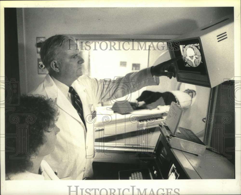 1984 Press Photo Arthur J. Wendte looks at image of vertebrae of patient - Historic Images