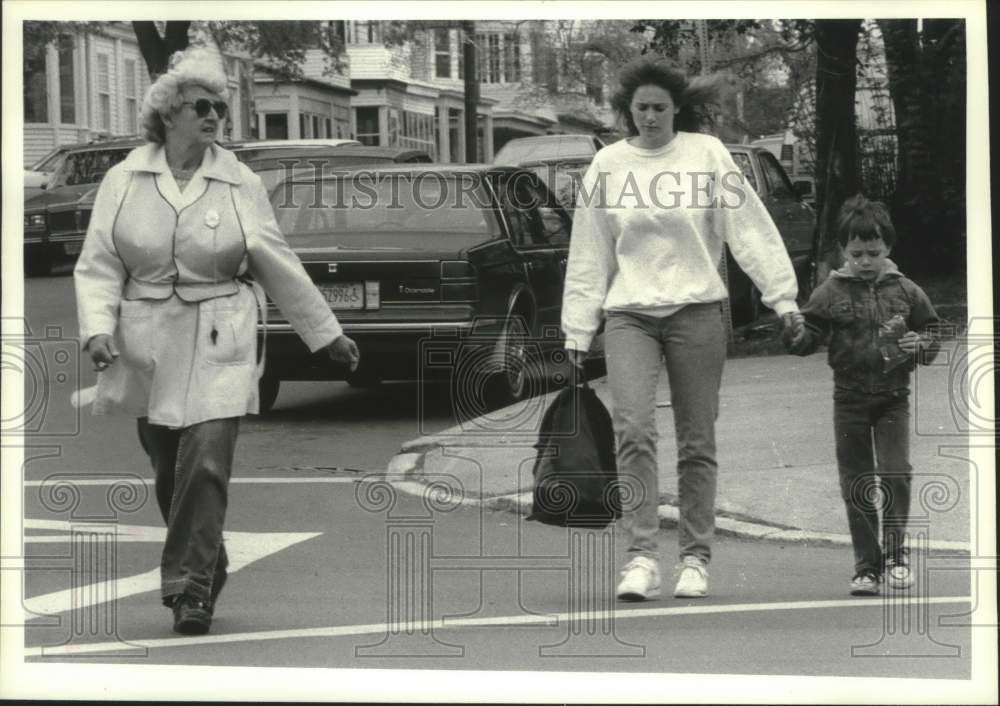1991 Press Photo Albany, NY crossing guard helps family across Albany roadway - Historic Images