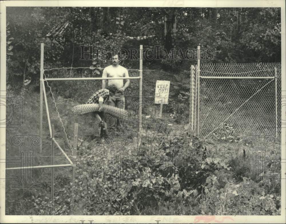 1982 Press Photo Two men working on fence installation behind NL Industries, NY - Historic Images