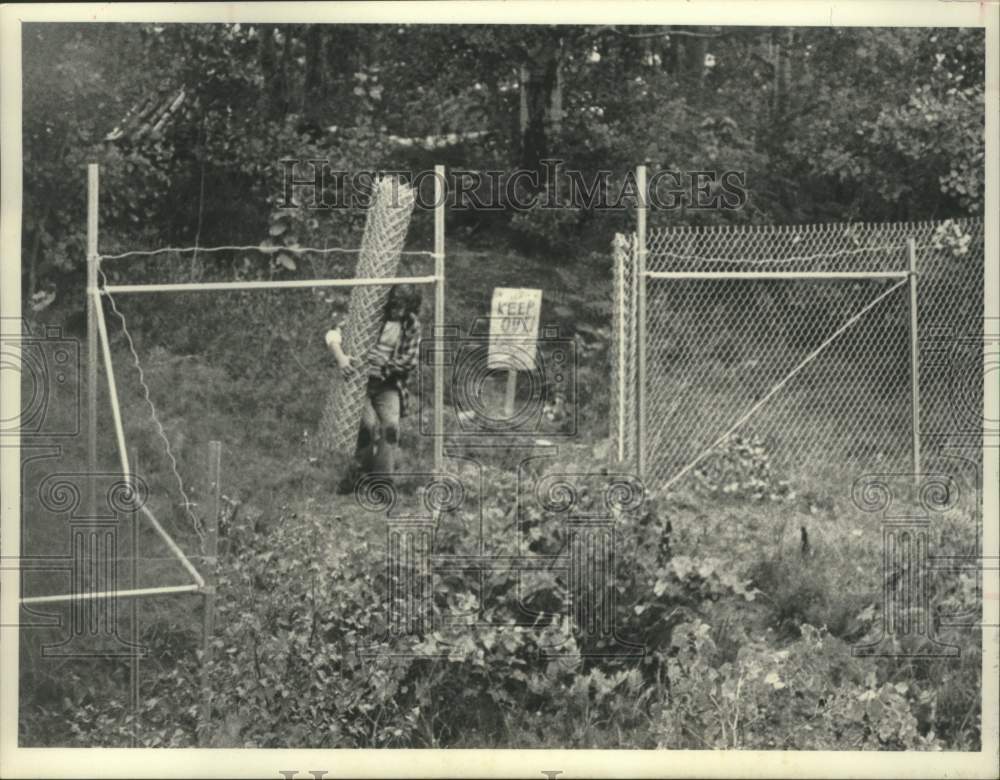 1982 Press Photo Two men working on fence installation behind NL Industries, NY - Historic Images