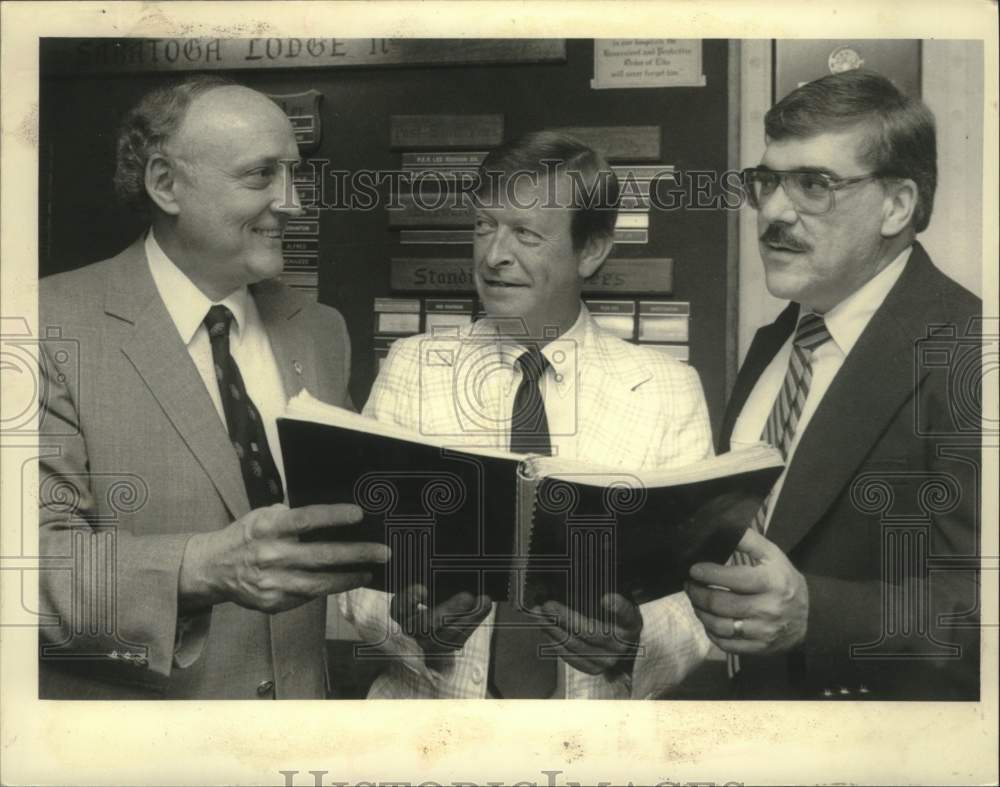 1986 Press Photo Saratoga County, New York politicians look at book at Elks Club - Historic Images