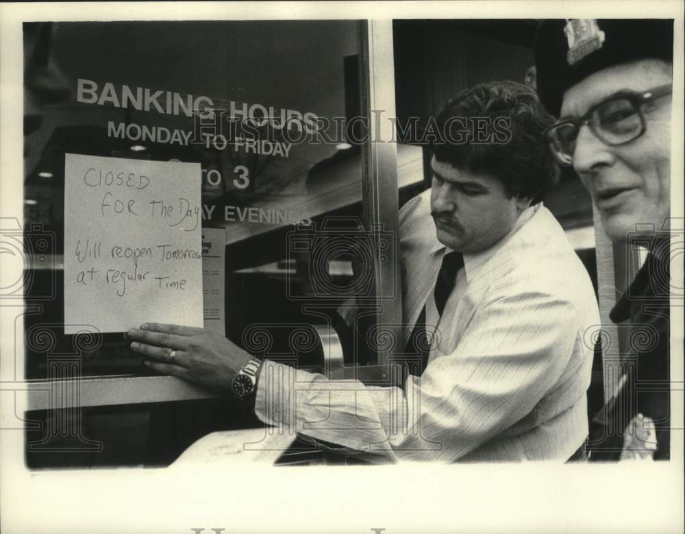 1983 Press Photo Albany, New York bank staff hangs sign closing bank for the day - Historic Images