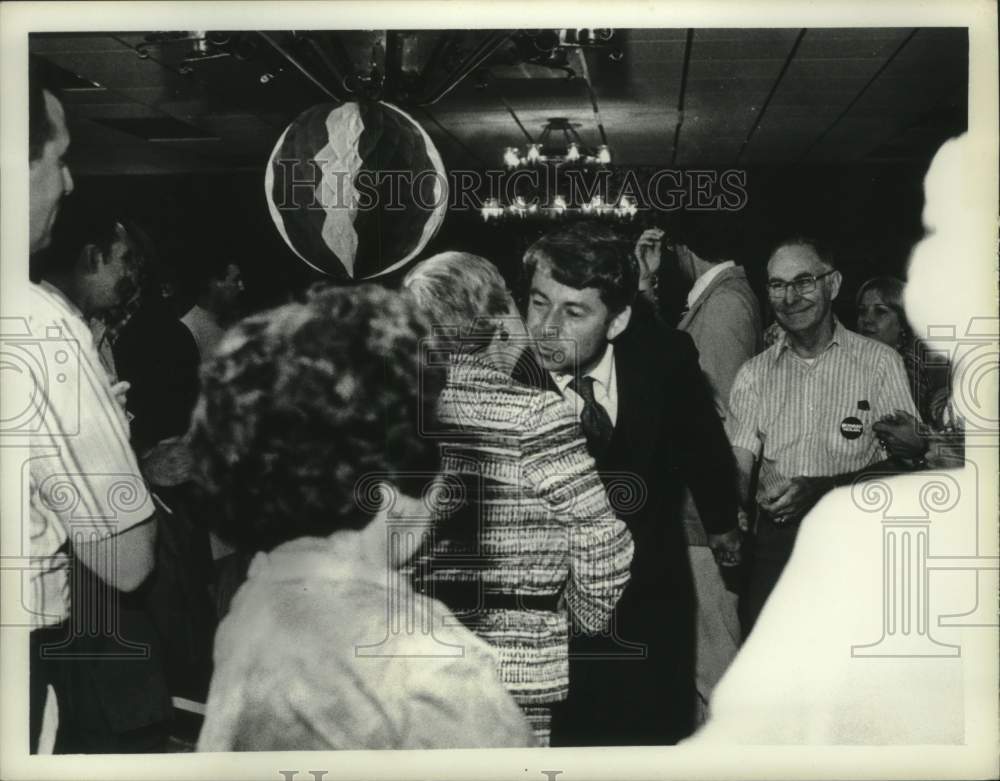 1977 Howard Nolan kisses unknown person surrounded by others - Historic Images