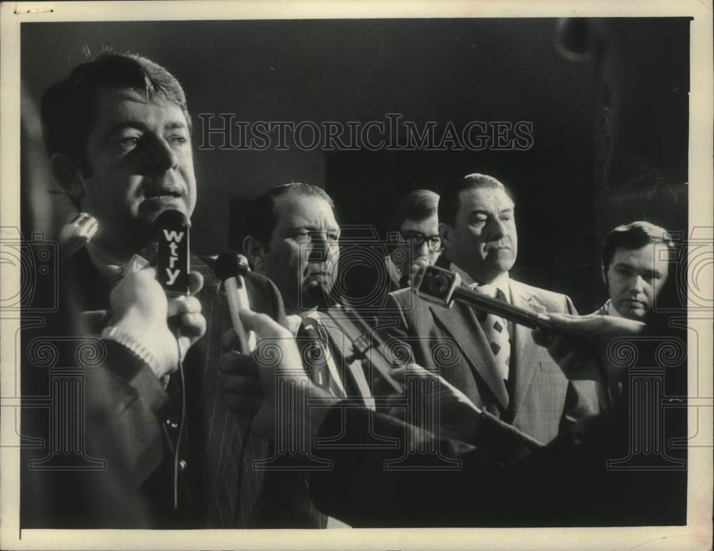1975 Press Photo Howard Nolan speaks to reporters with others observing - Historic Images