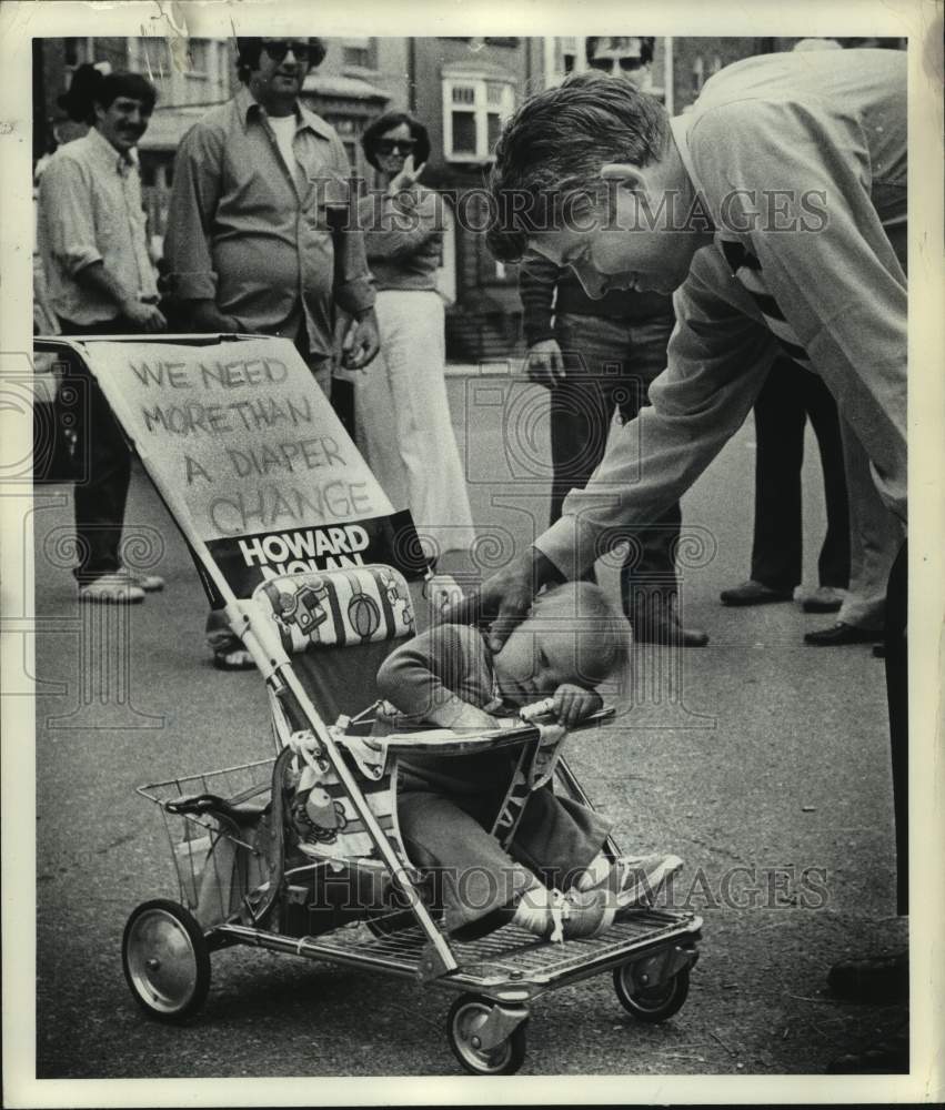 1977 Press Photo New York State Senator Howard Nolan greets infant in Albany - Historic Images