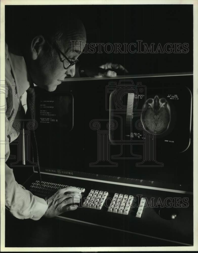 1983 Press Photo Doctor looks at images from Magnetic Resonance Imaging machine - Historic Images