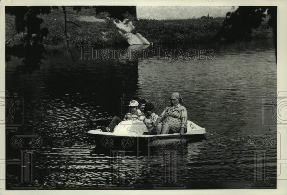 1988 Press Photo Group enjoying a paddleboat on an Albany, New York park lake - Historic Images