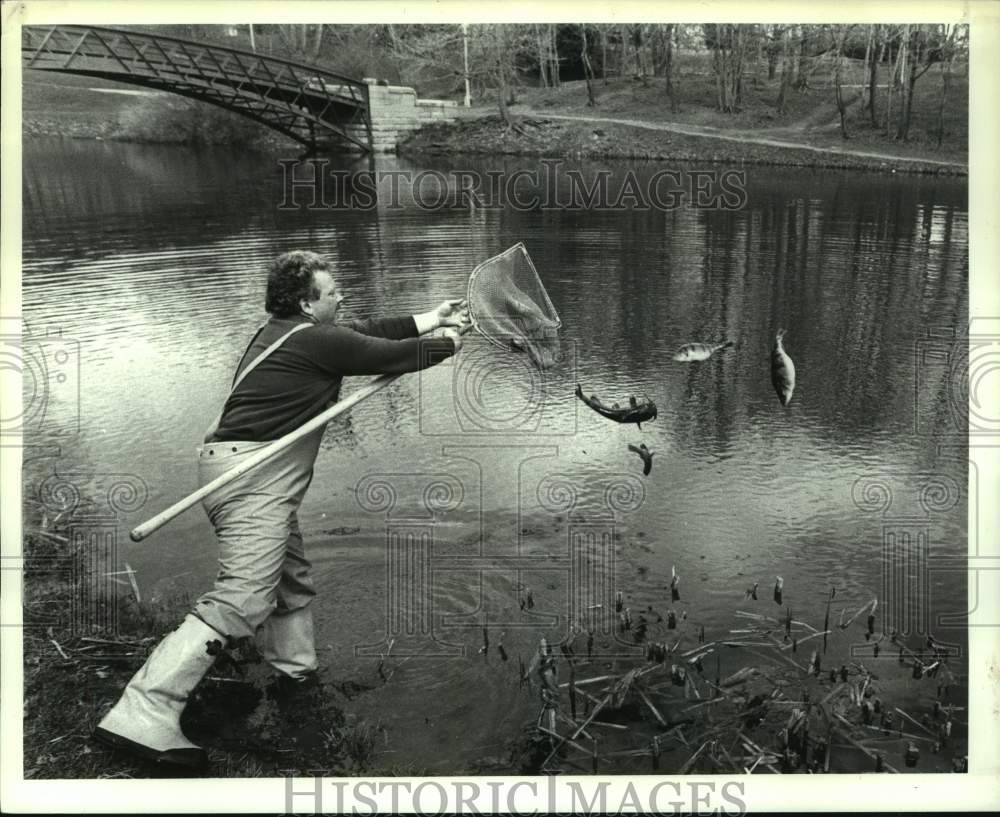 1991 Press Photo John Lasch restocks fish in Washington Park Lake, Albany, NY - Historic Images