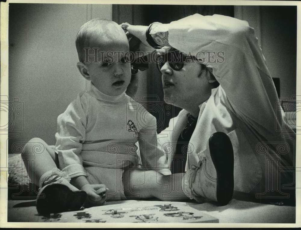 1976 Press Photo Nurse examines infant&#39;s ear in Albany, New York - tua15335 - Historic Images