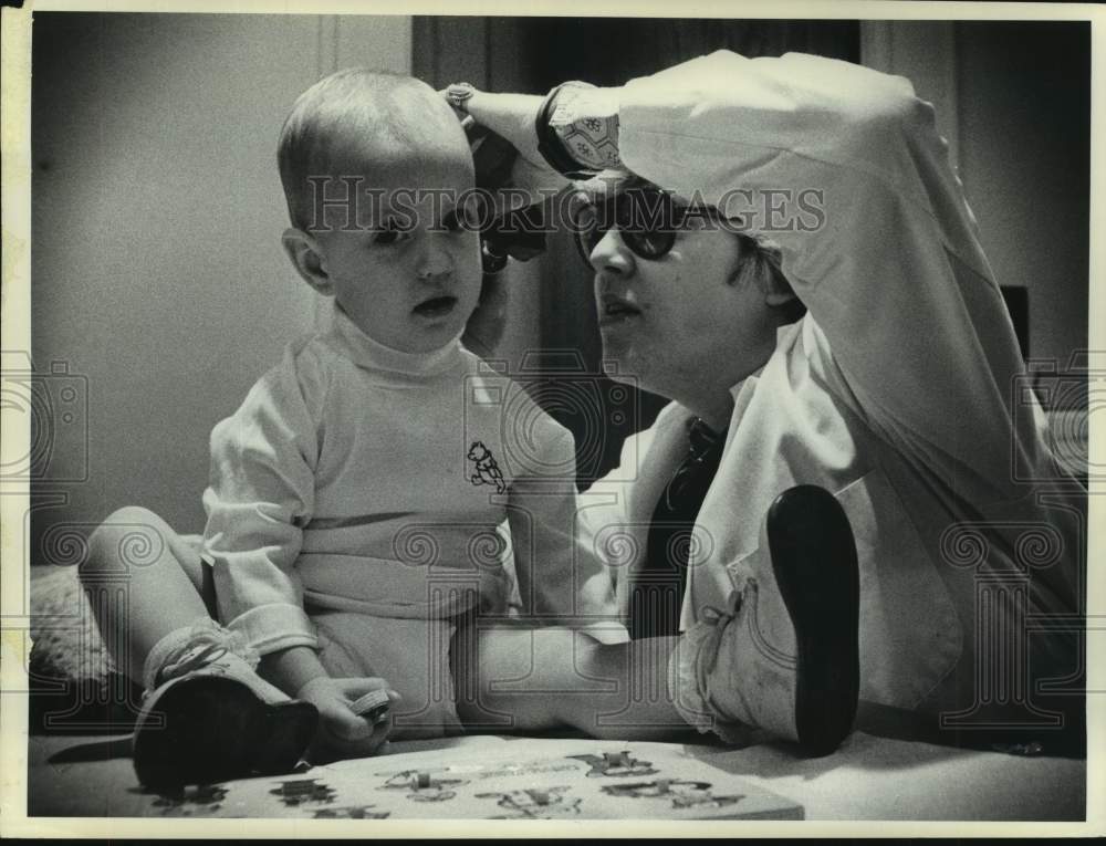 1976 Press Photo Nurse examines infant's ear in Albany, New York - tua15335 - Historic Images