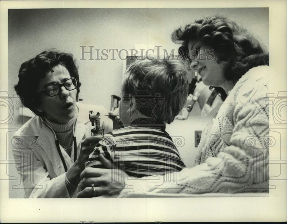 1976 Press Photo Sister Lucy Cresanti examines toddler in Albany, New York - Historic Images