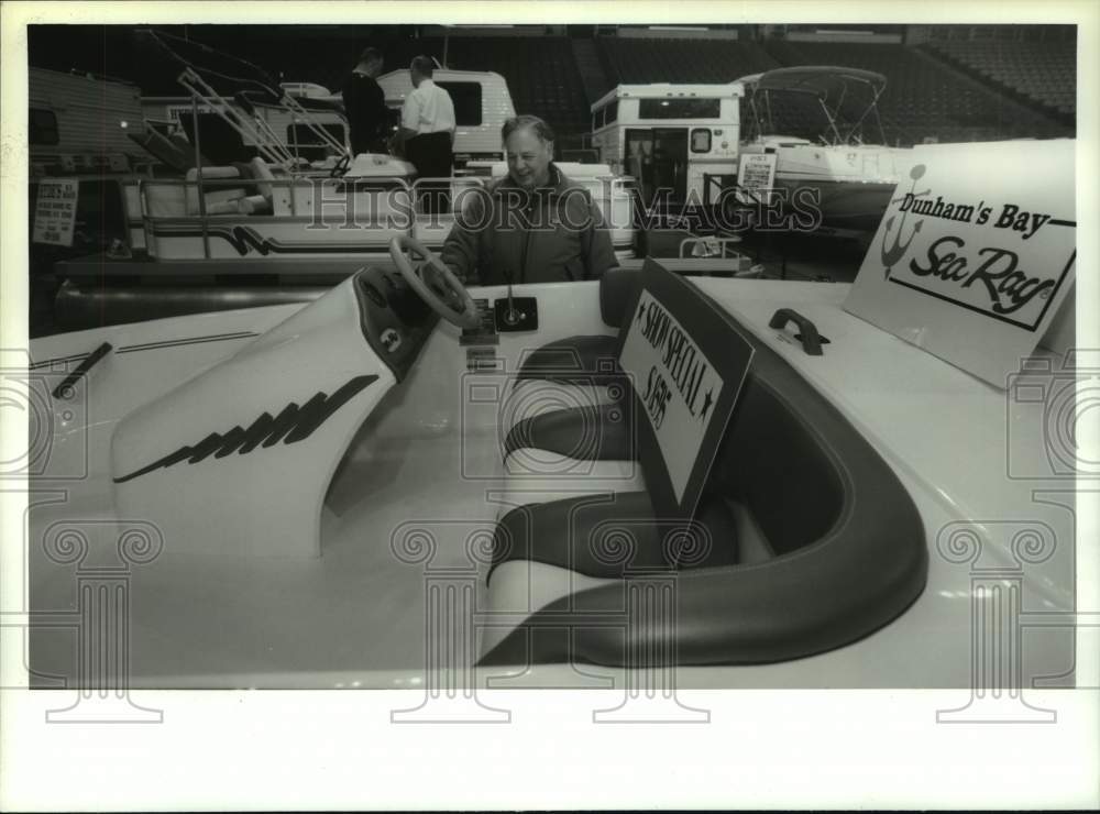 1994 Victor Zaccaro admires boat at Albany, New York outdoor expo - Historic Images