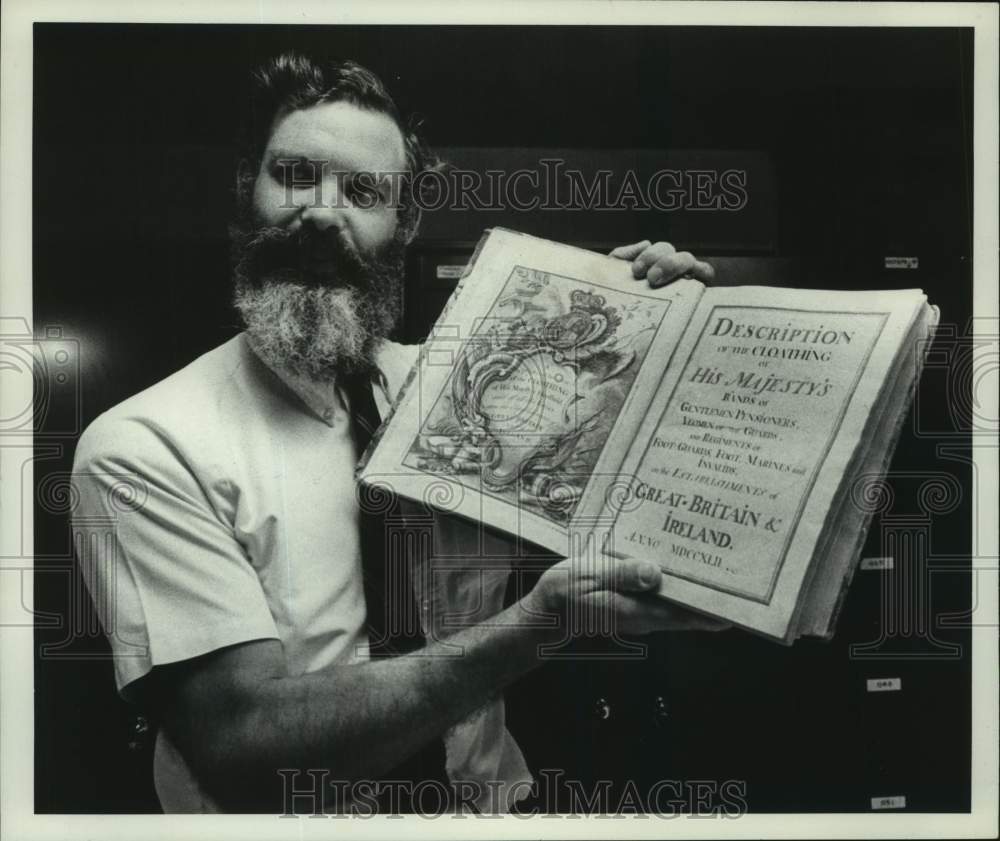 1977 Press Photo Darrell Welch shows antique book in West Sand Land, New York - Historic Images