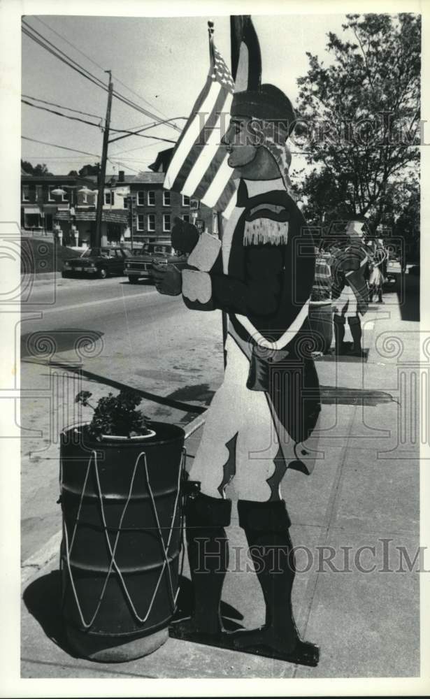 1987 Press Photo Sentinels line Main St, Schuylerville, NY guarding flower pots - Historic Images