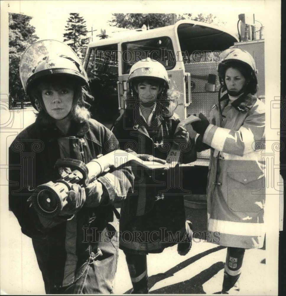 1986 Press Photo Scotia New York female firefighters carrying hose from truck. - Historic Images