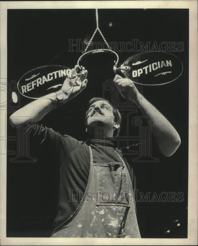 1981 Press Photo Schenectady Museum curator hangs sign for exhibit in New York - Historic Images