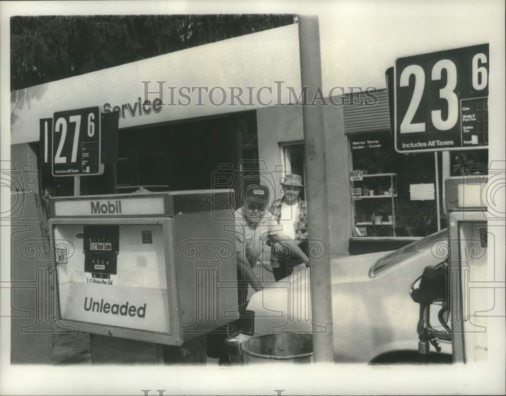 1980 Schuylerville, NY Mobil station owner pumps gas for customer - Historic Images