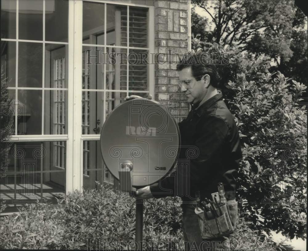 1994 Press Photo Unidentified man installing RCA DSS satellite dish outside home - Historic Images
