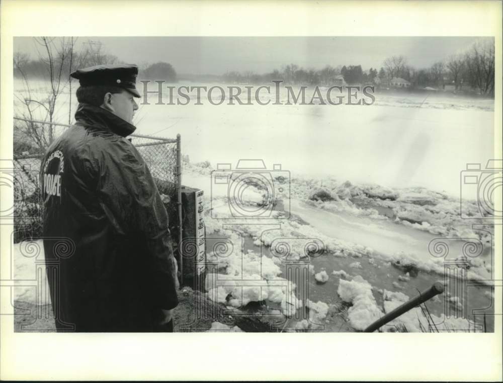 1993 Press Photo Schenectady, NY Police Officer looks over ice covered river - Historic Images