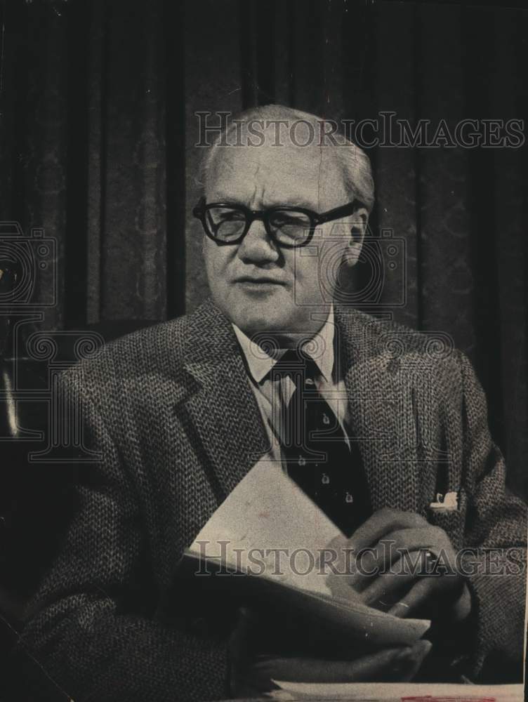 Press Photo Ewald B Nyquist, sits in chair holding papers - Historic Images