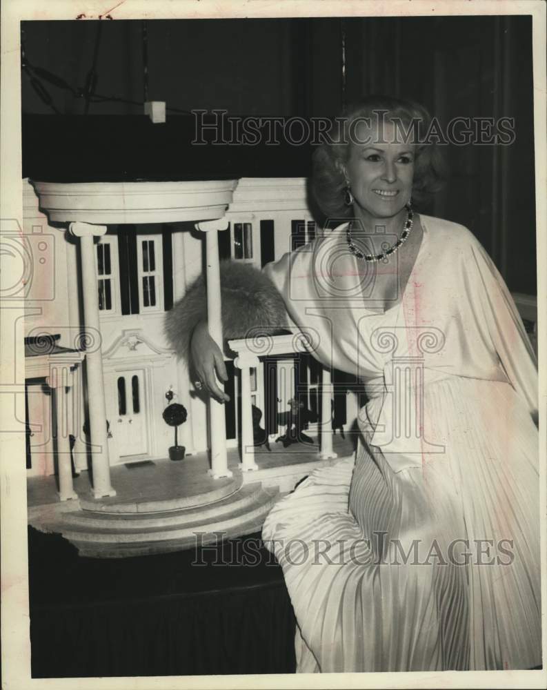 1976 Mary Ann Whitney, dressed in gown, in front of model of house - Historic Images