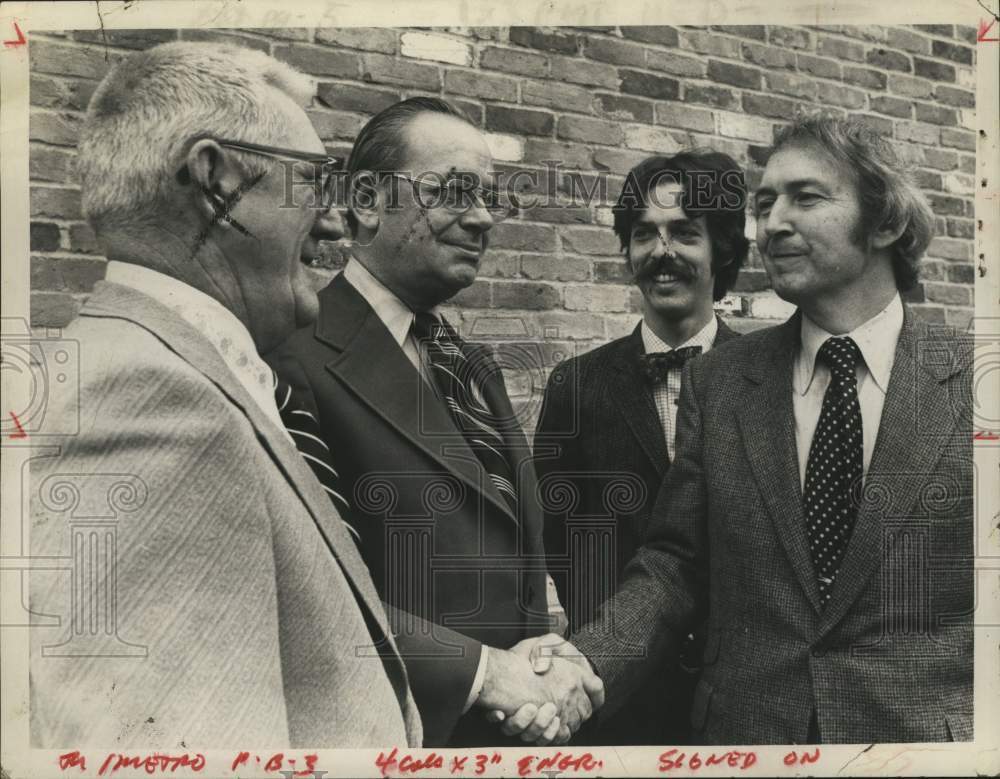 1973 Mayor Raymond Watkin (R) shakes hands with other men outdoors - Historic Images