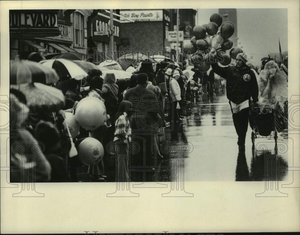 1974 Man with balloons for sale walks down St Patrick's Day parade - Historic Images