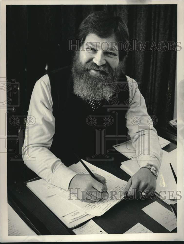 1985 Paul F Lotters, owner of "Alive" magazine, sits at his desk - Historic Images