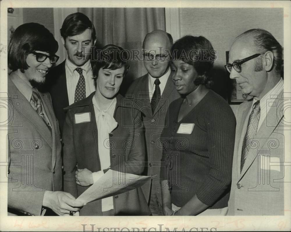 1972 Educational group looks over paper at meeting in New York - Historic Images