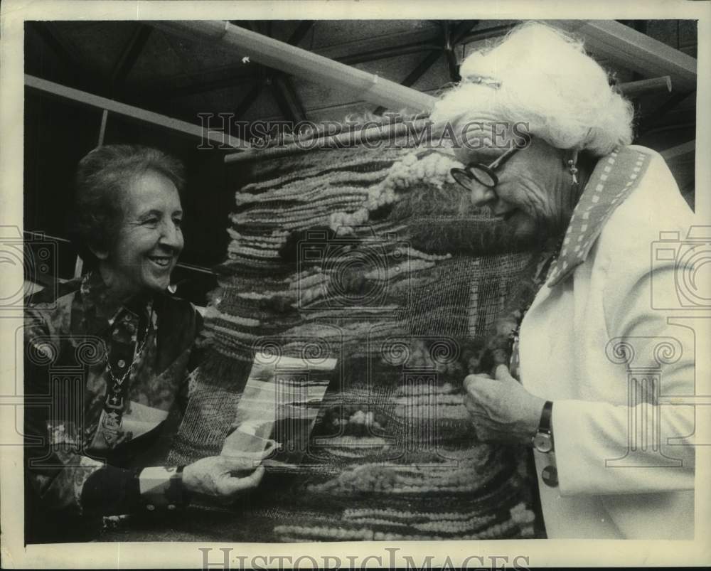 1974 Mrs. Ewald Nyquist admires Lotti Speth handweaving in New York - Historic Images