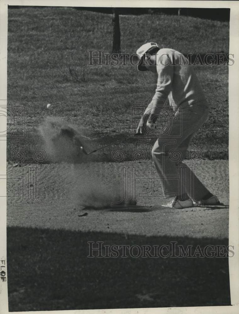 Golfer Jim Wright chips ball out of sand trap on first hole of match - Historic Images