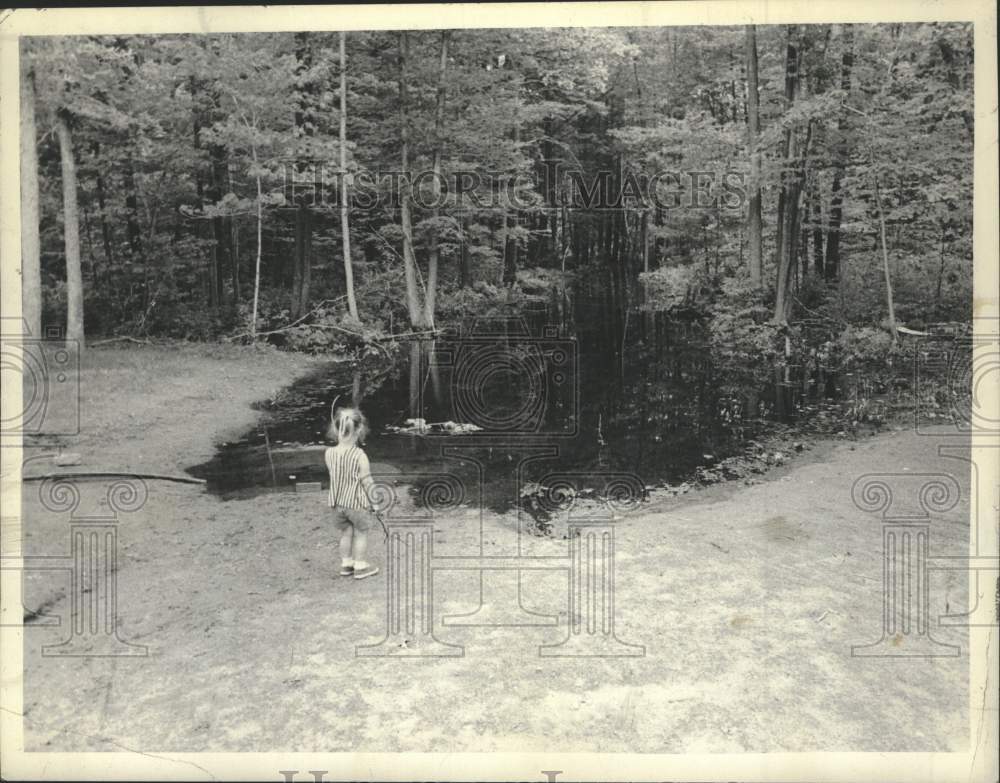 1972 Child looks at standing water behind her Milton, New York home - Historic Images