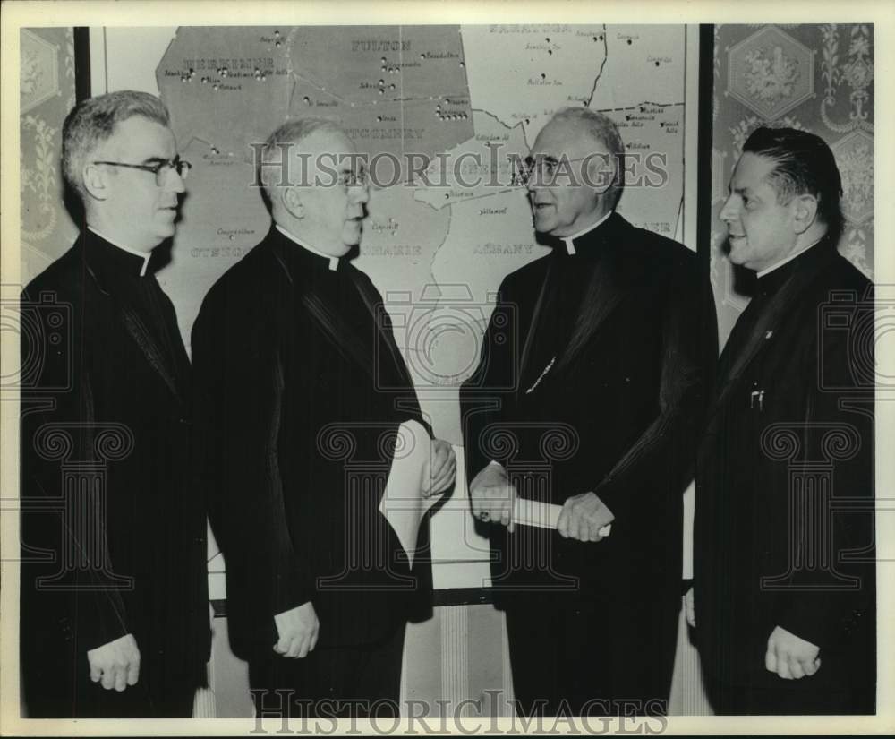 Press Photo Bishop Edward J Maginn talks to other priests in front of large map - Historic Images