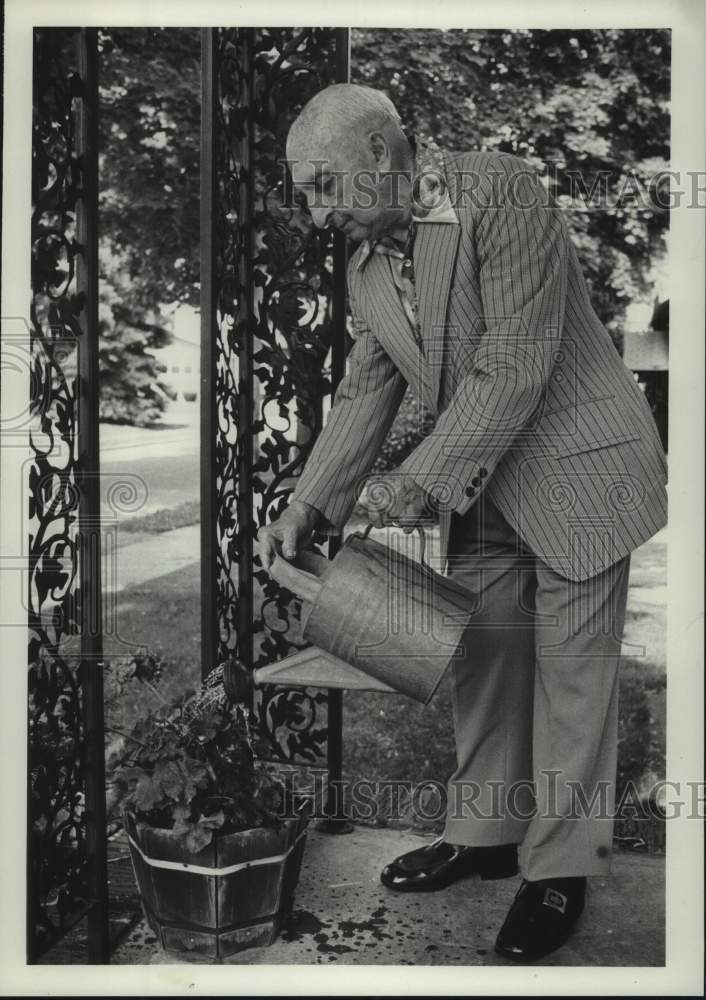 1979 Charles F. Moehle waters plants at his New York home - Historic Images