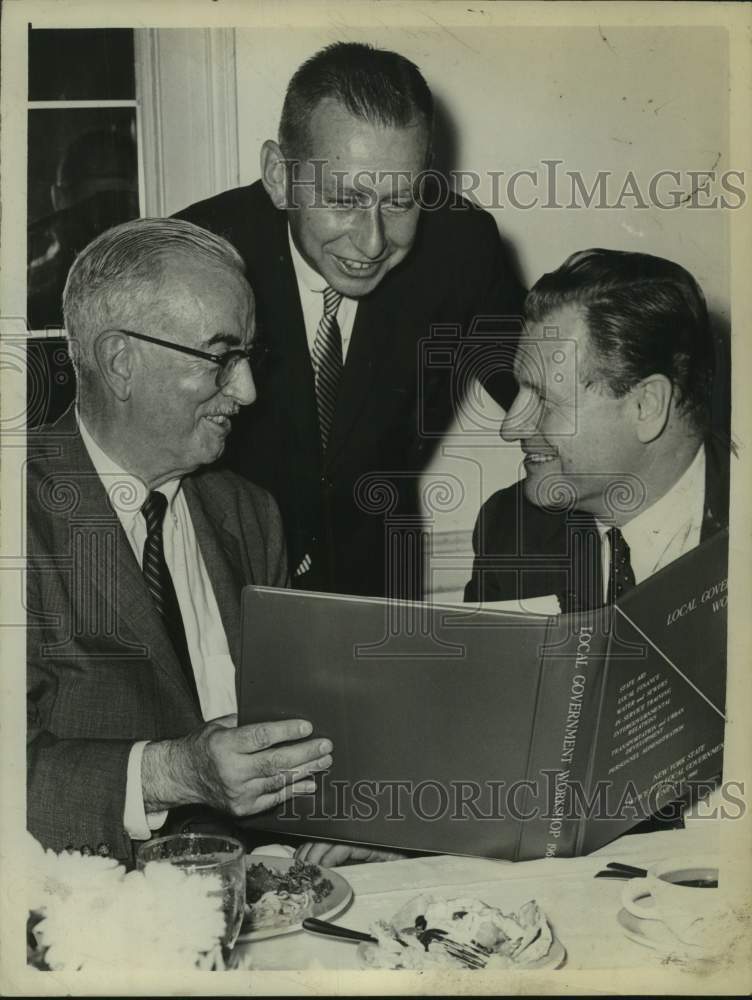 1961 Frank C Moore, Malcolm Wilson, &amp; Governor Rockefeller read book - Historic Images