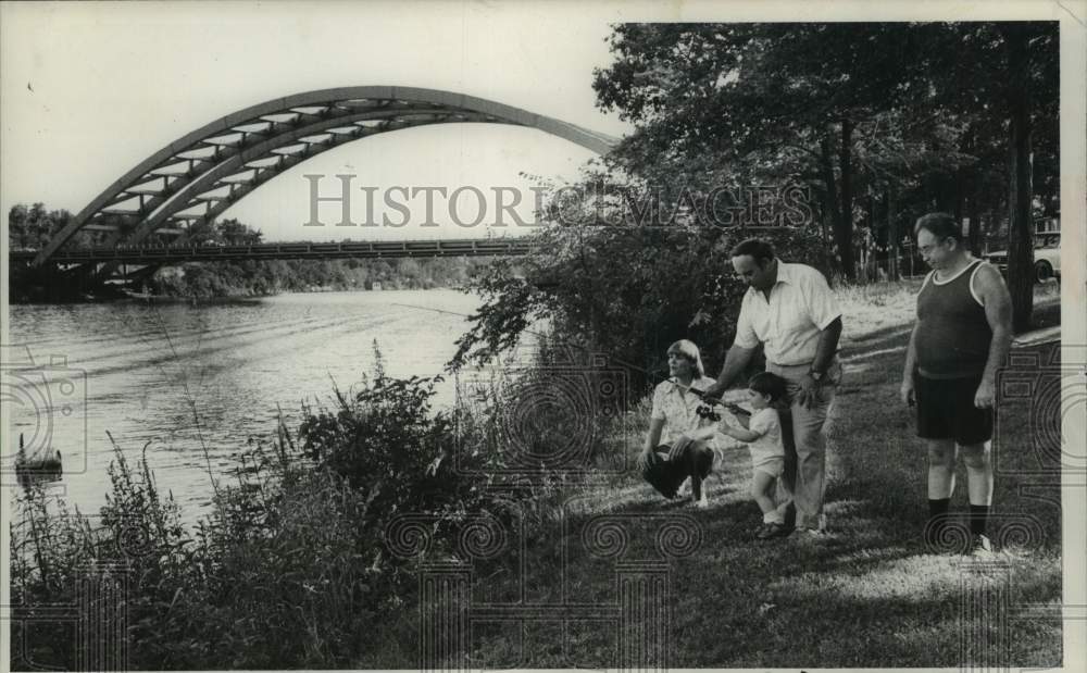 1980 Family teaches young boy to fish on Mohawk River bank, New York - Historic Images