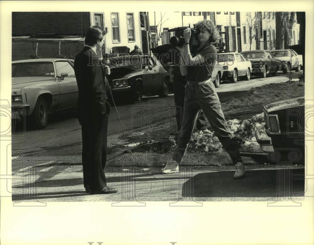 Press Photo Camera operator films reporter in New York neighborhood - Historic Images