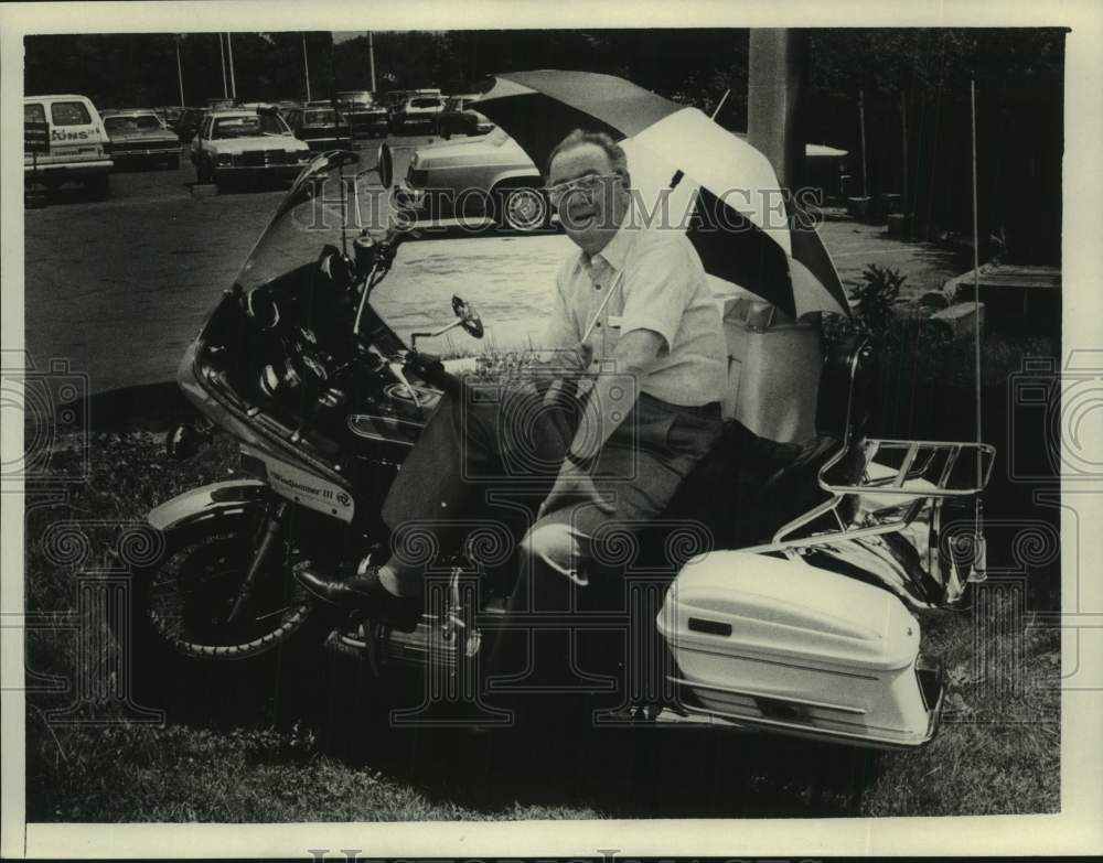 1981 Lee Marks sits on motorcycle in the rain in New York - Historic Images