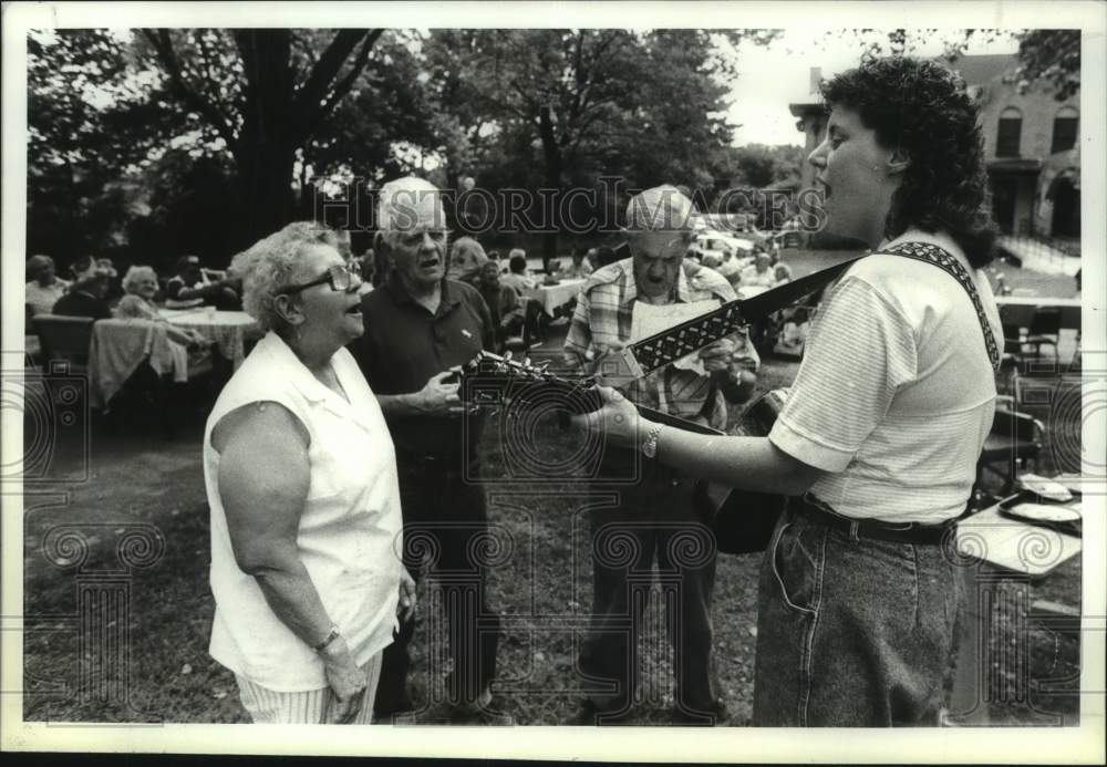 1990 Press Photo Elderly group sings along with guitarist at New York day care- Historic Images