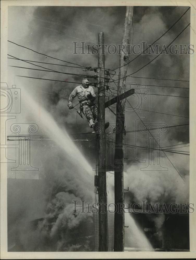 1963 Press Photo Telephone lineman repairs wires during fire in Albany, New York- Historic Images
