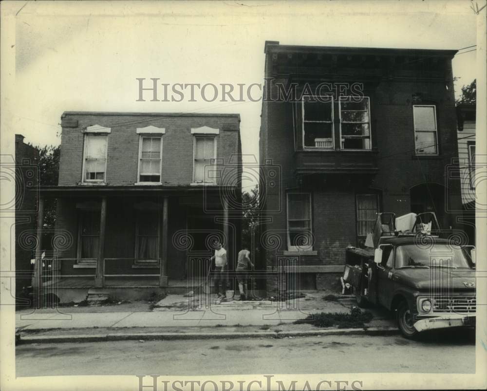 1973 Men clean up outside homes on Broadway in Rensselaer, New York - Historic Images
